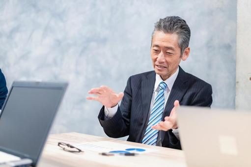 スーツで意見を述べる経営者 スーツで意見を述べる経営者 会社,株主総会,意見の写真素材