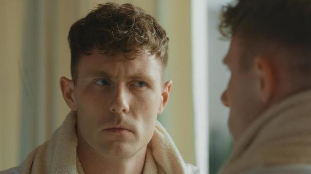 鏡で自分の顔をチェックしている風呂上がりの男性 男性,外国人,欧米人の写真素材