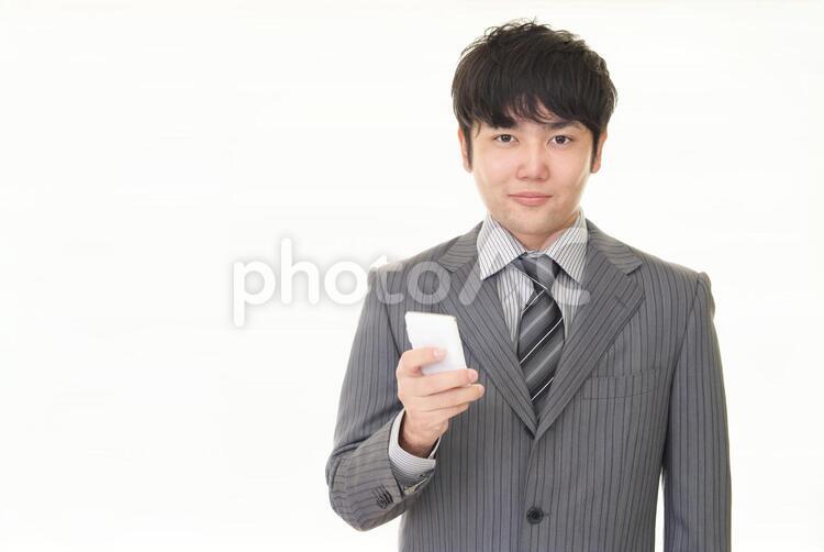 スマートフォンを持つビジネスマン 男性,ビジネスマン,男の写真素材
