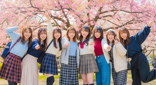 春爛漫の桜の下で笑顔あふれる女子学生 春爛漫の桜の下で笑顔あふれる女子学生の写真