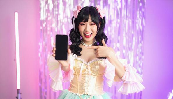 アイドルの曲を携帯からリクエストする女性 アイドルの曲を携帯からリクエストする女性の写真