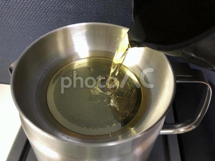 から揚げで使った油を油こし器で精製する 油,フライヤー,ステンレスの写真素材