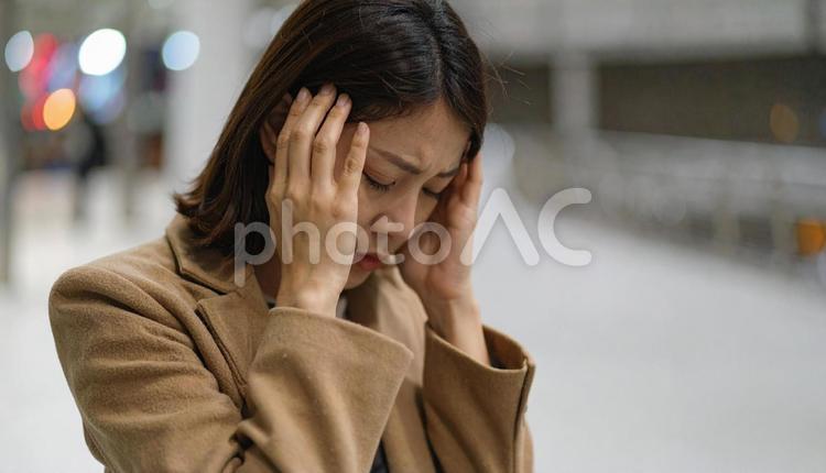 頭を抱えて落ち込む日本人女性 女性,ビジネスウーマン,キャリアウーマンの写真素材