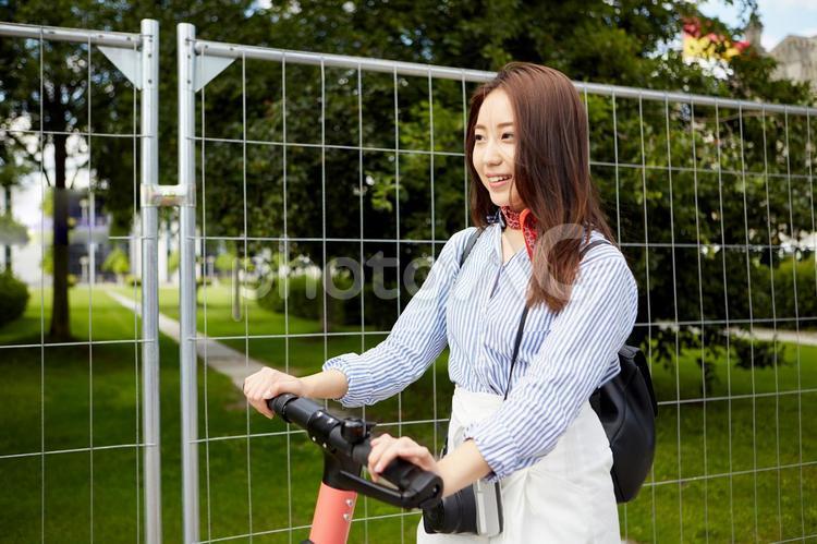 キックボードに乗る海外旅行中の女性1 海外旅行,女性,日本人の写真素材