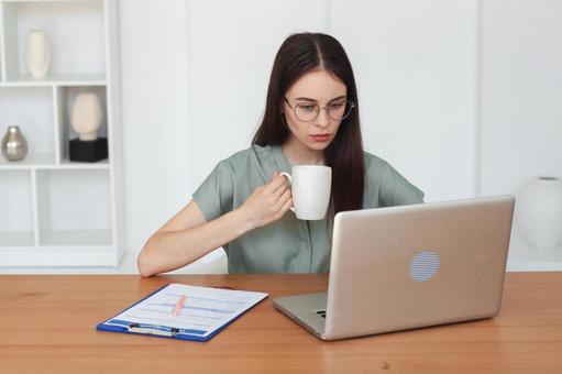 ノートPCと向き合う眼鏡をかけた女性 保険業,事務職,接客業の写真素材