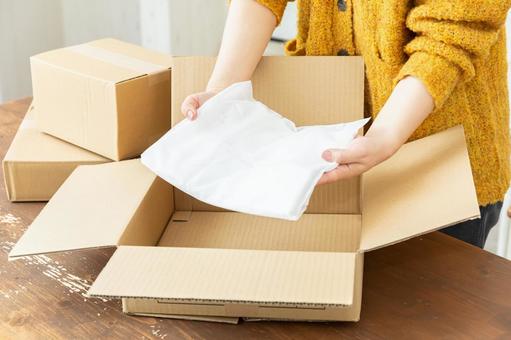 洋服を梱包する女性の手元 衣服,衣類,段ボールの写真素材