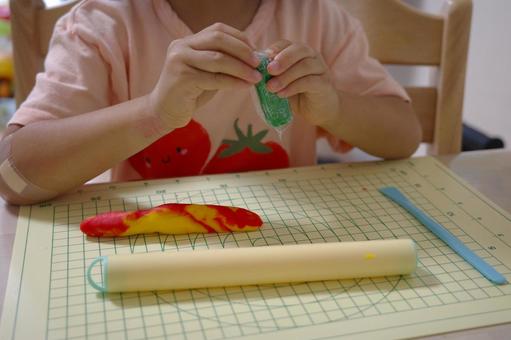 お家遊びで小麦粘土を開封する子ども お家遊びで小麦粘土を開封する子ども 粘土,子ども,家の写真素材