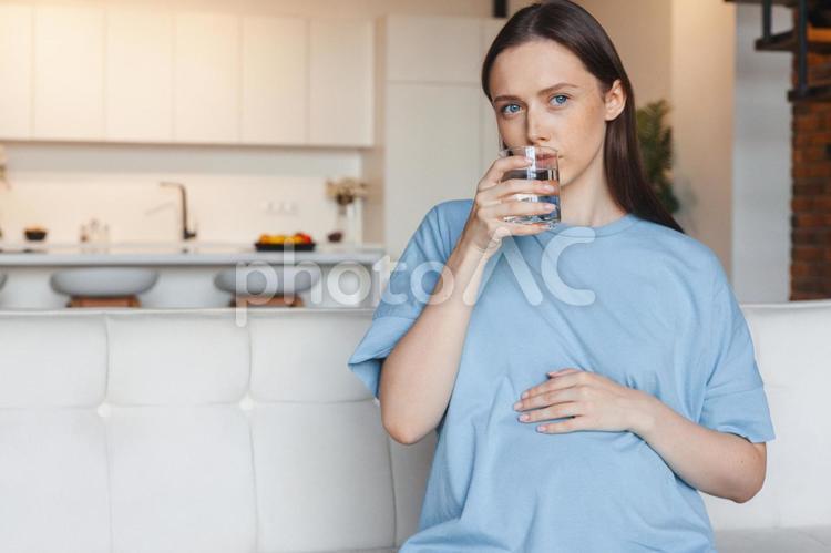 水を飲みながらどこかを見ている女性 女性,人物,妊婦の写真素材