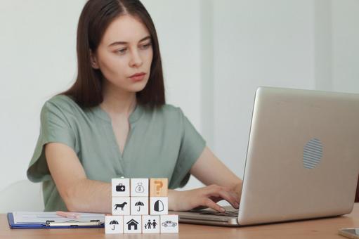 キューブとノートPCを見るの女性スタッフ 保険業,事務職,接客業の写真素材