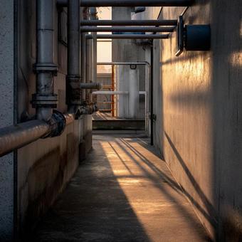 夕日に照らされた工場の配管と影 夕日に照らされた工場の配管と影の写真