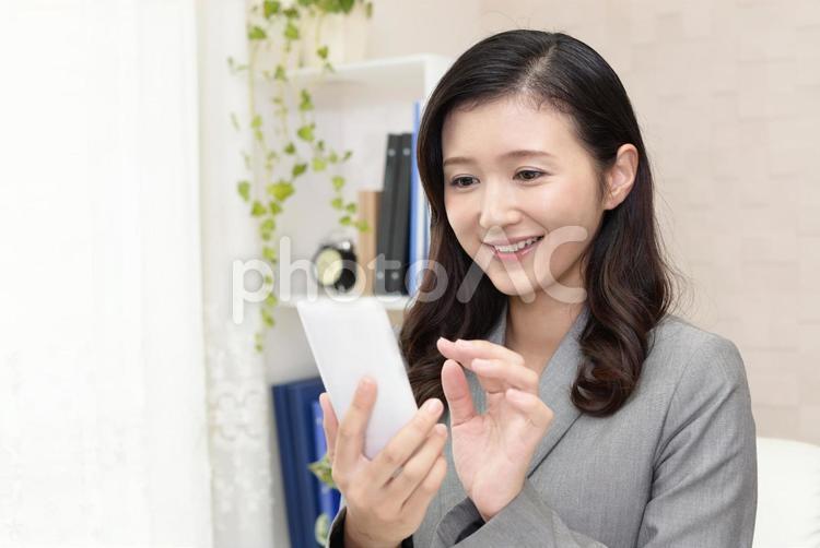 スマートフォンを持つ笑顔のビジネスウーマン 女性,ビジネスウーマン,女の写真素材