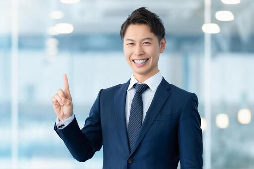 人差し指を立てて案内する男性ビジネスマン 男性,案内,笑顔の写真素材