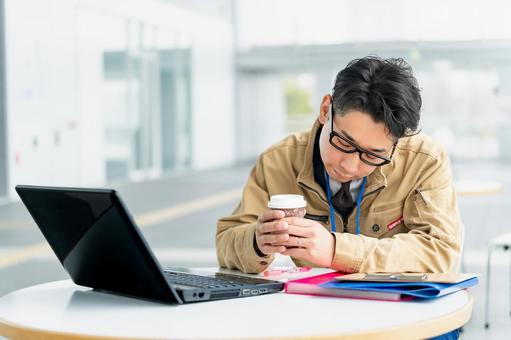 ドリンクを持ちながら項垂れる作業服の男性 ドリンクを持ちながら項垂れる作業服の男性 ビジネス,ビジネスマン,作業員の写真素材