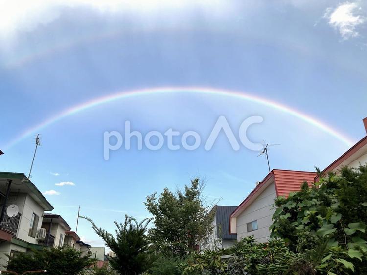 住宅街にかかる虹 レインボー,青空,雲の写真素材