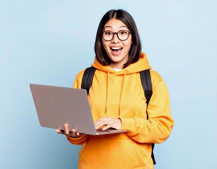 驚いた表情の大学生とPC 驚いた表情の大学生とPCの写真