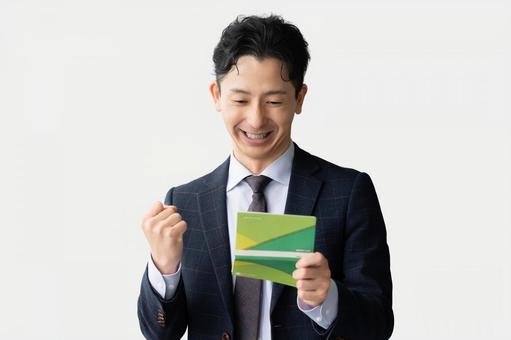 通帳を見て喜ぶ男性ビジネスマン 通帳を見て喜ぶ男性ビジネスマン 男性,ビジネス,ビジネスマンの写真素材