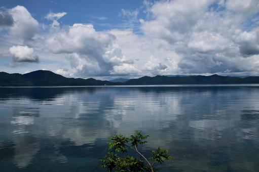 田沢湖の穏やかな湖面と空の風景 田沢湖の穏やかな湖面と空の風景の写真