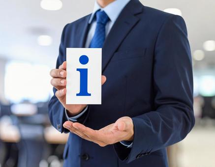 インフォメーション「i」を手に持つ男性 の写真