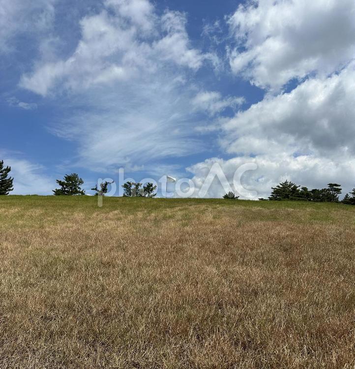 夏の小高い丘に立つゴルフのの一本の白い旗 自然,風景,景色の写真素材