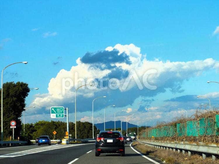 白い大きな雲に寄り添う小さい黒い雲 ハイウェイ,車,雲の写真素材
