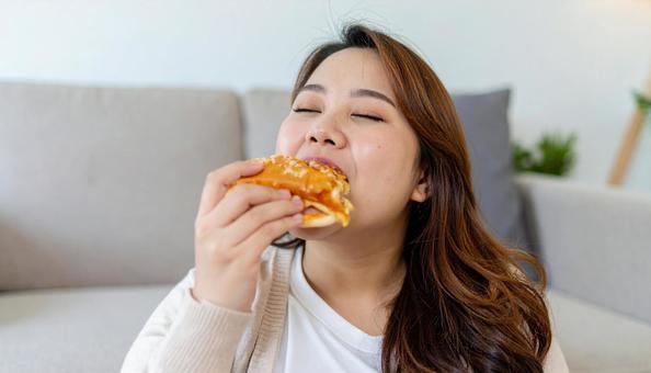 チートデイ ジャンクフードを食べる女性 チートデイ ジャンクフードを食べる女性の写真