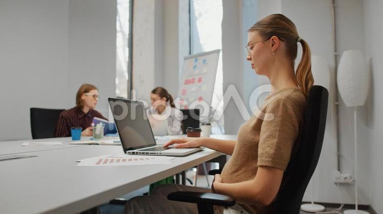オフィスでノートパソコンを使う妊娠中の女性 ビジネス,ビジネスマン,ビジネスウーマンの写真素材