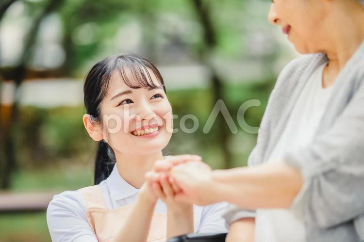 車椅子に乗った高齢者女性と女性スタッフ 介護士,介護福祉士,看護師の写真素材