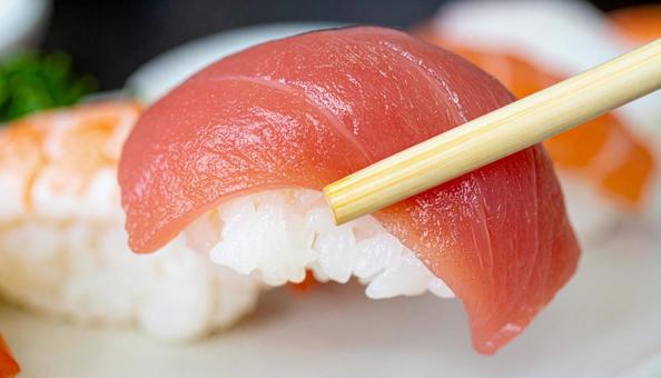 皿に盛られた美味しそうな寿司を箸でつまむ 皿に盛られた美味しそうな寿司を箸でつまむの写真