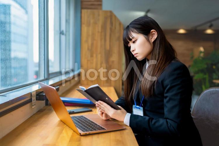 デスクで手帳を眺めるビジネスウーマン ビジネスウーマン,ビジネス,女性の写真素材