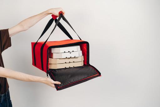 保温ピザバッグを開けて差し出す手 配達,フードデリバリー,テイクアウトの写真素材