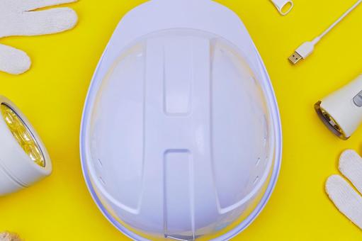 黄色背景の上のヘルメットと防災グッズ ヘルメット,防災,用品の写真素材