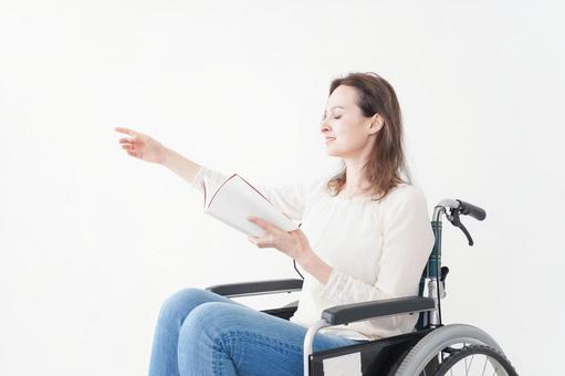 車椅子に乗り読書をする外国人の女性 本読み,読書,歩行困難の写真素材