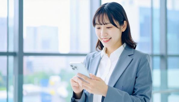 スマホを確認するビジネス女性 スマホを確認するビジネス女性の写真