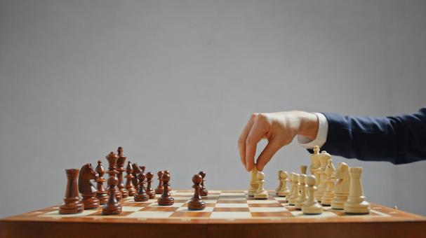 チェスをするスーツの男性の手(グレー背景) チェスをするスーツの男性の手(グレー背景) チェス,男性,30代の写真素材