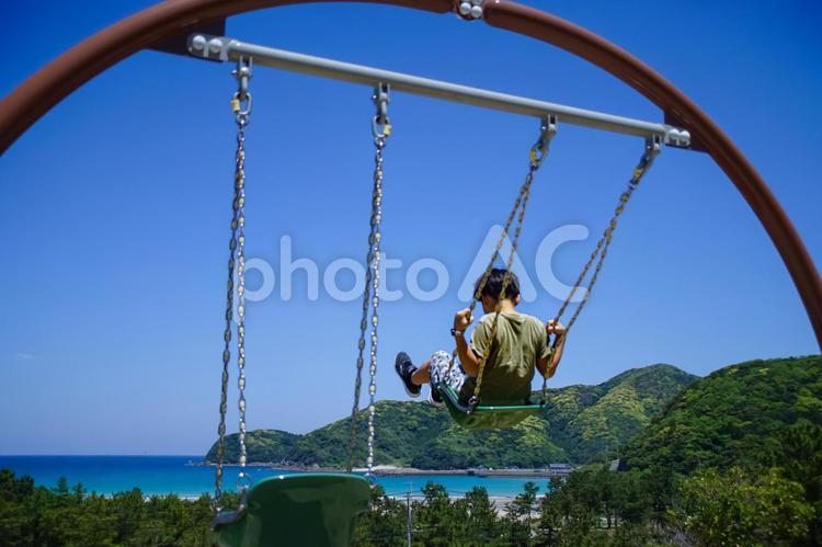 R＜素材＞大空にブランコで舞い上がる少年 子供,ブランコ,空の写真素材