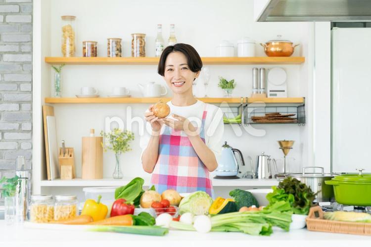 キッチンのエプロン姿の主婦 キッチン,エプロン,野菜の写真素材