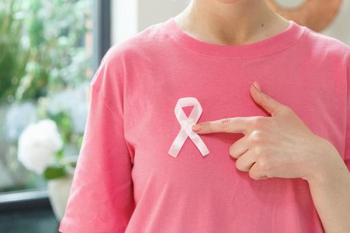 ピンクリボン胸につけて指さしている女性 生理,月経,女性の写真素材