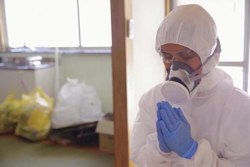 防護服で合掌をする特殊清掃員 防護服で合掌をする特殊清掃員 合掌,手を合わせる,供養の写真素材