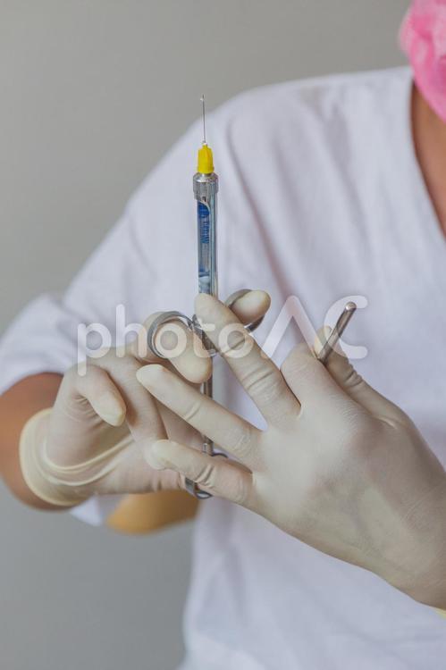 注射器を持つ歯科医の手元2 歯医者,注射器,麻酔の写真素材