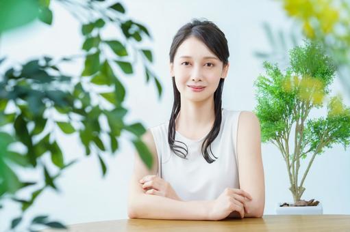 緑に囲まれた部屋で笑顔の女性 緑に囲まれた部屋で笑顔の女性 女性,若い女性,グリーンの写真素材