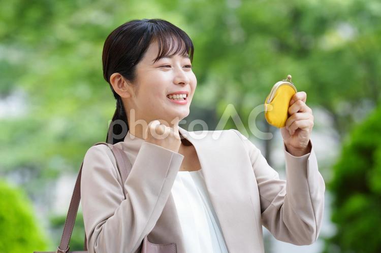 がま口を見てガッツポーズする女性 女性,人物,大学生の写真素材