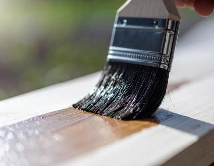 刷毛で板にワックスを塗る様子の写真