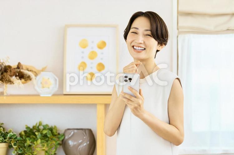 スマホを持つ笑顔の女性　主婦 主婦,スマホ,女性の写真素材
