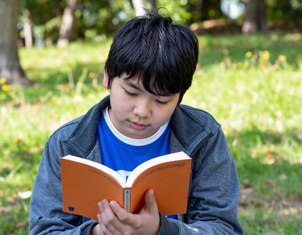 公園で本を読む少年 公園で本を読む少年の写真