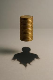 金貨の影に潜む人影 金貨の影に潜む人影の写真