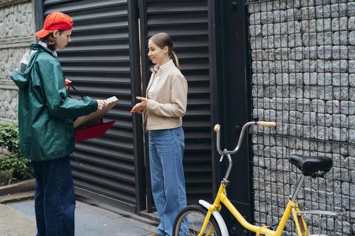 門の前でピザ渡すフードデリバリーの男性 配達,フードデリバリー,デリバリーの写真素材