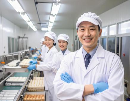 食品工場で制服姿で笑顔の男女の作業員 食品工場で制服姿で笑顔の男女の作業員の写真