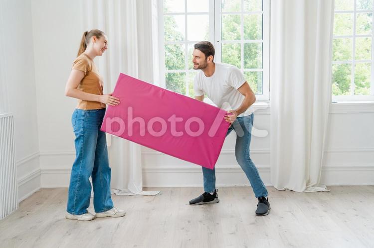 仲良く笑顔で荷物を運ぶ男女 運ぶ,笑顔,楽しいの写真素材