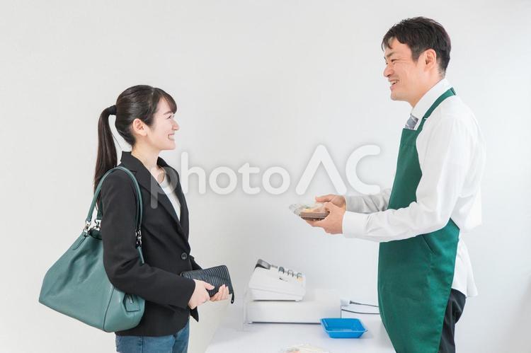 お弁当を買う女性と笑顔のコンビニ店員 レジ,レジ打ち,笑顔の写真素材