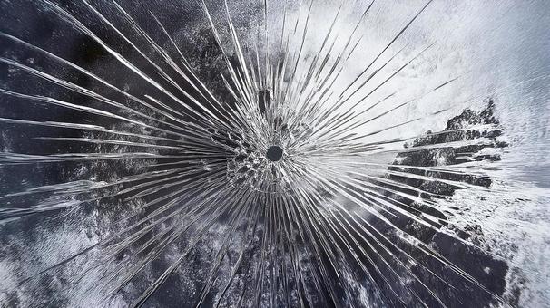 弾痕が残る割れたガラスの背景画像 弾痕が残る割れたガラスの背景画像の写真